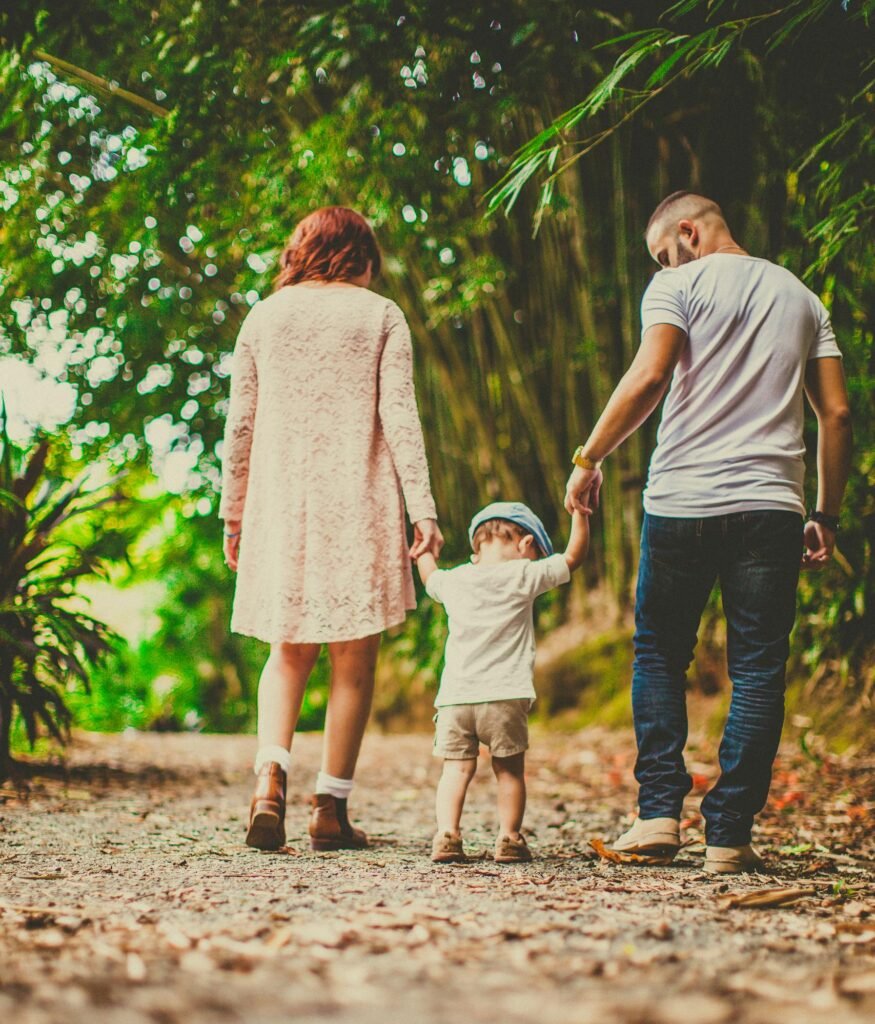 A family enjoys a leisurely walk in a green park, embodying joy and togetherness.
